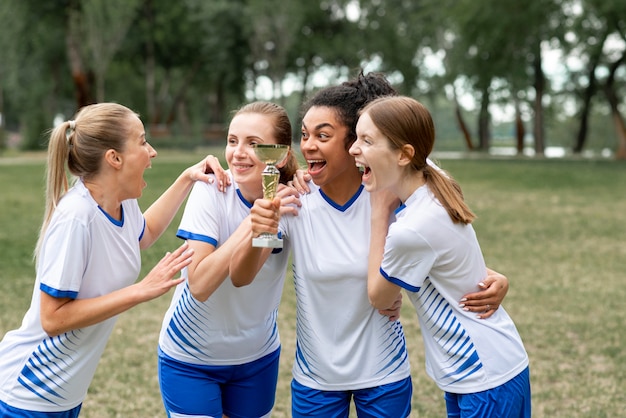 Excited women holding golden cup