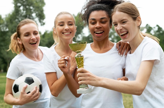 Foto gratuita donne emozionanti che tengono la tazza dei vincitori