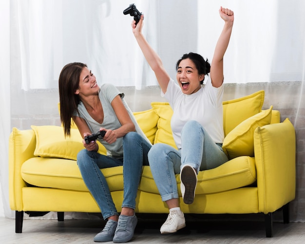 Excited women at home playing video games together