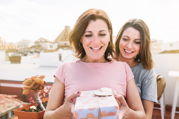 Excited women with present on street