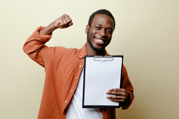 excited young african american male holding clipboard isolated on white background