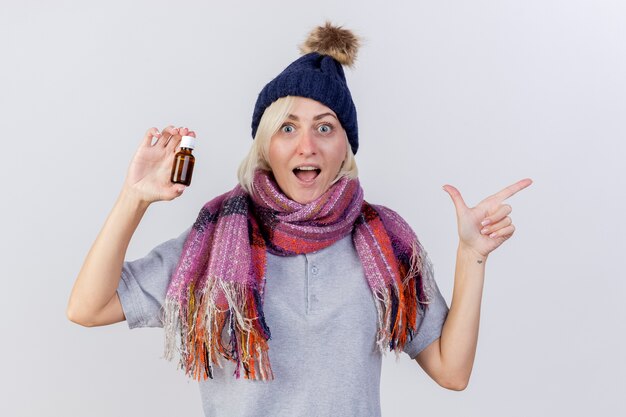 Excited young blonde ill slavic woman wearing winter hat and scarf