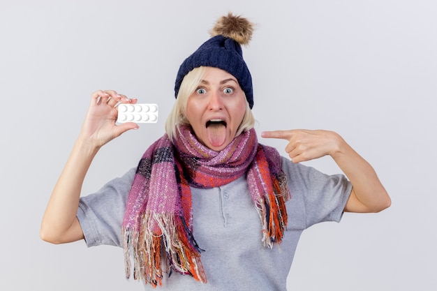 Excited young blonde ill slavic woman wearing winter hat and scarf