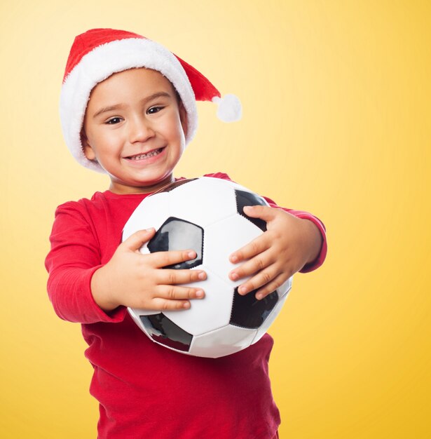 Excited young boy giving a hug to his new ball