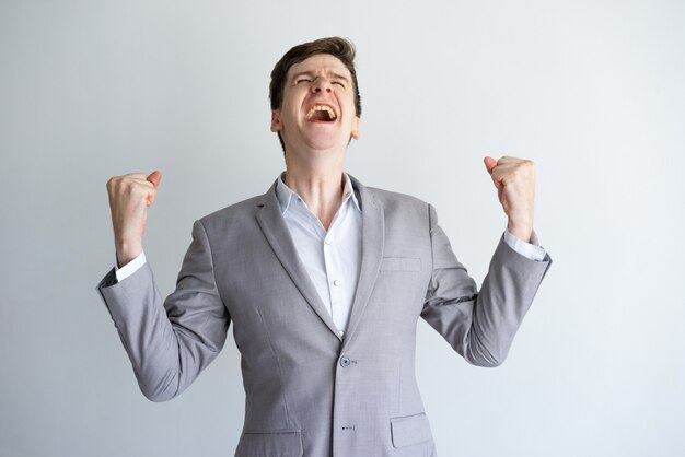 Excited young businessman enjoying success