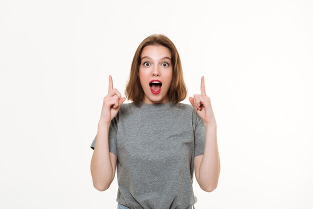 Excited young caucasian lady pointing.