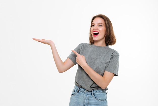 Excited young caucasian lady pointing.