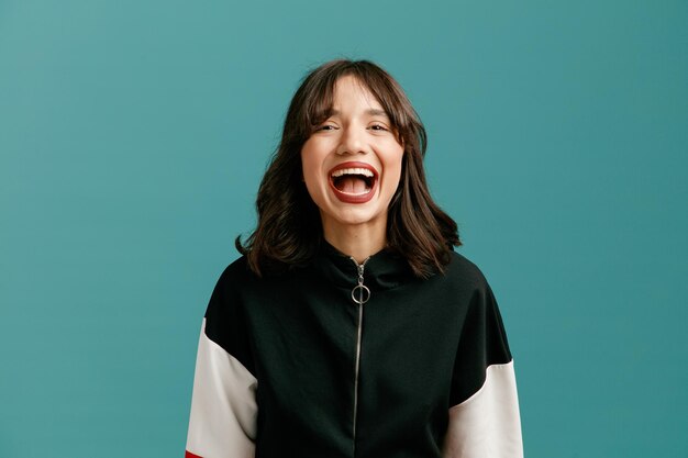 Excited young caucasian woman looking at camera isolated on blue background