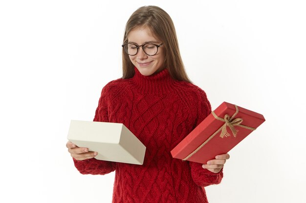 excited young female in glasses enjoying unexpected surprise present on her birthday, smiling, holding box