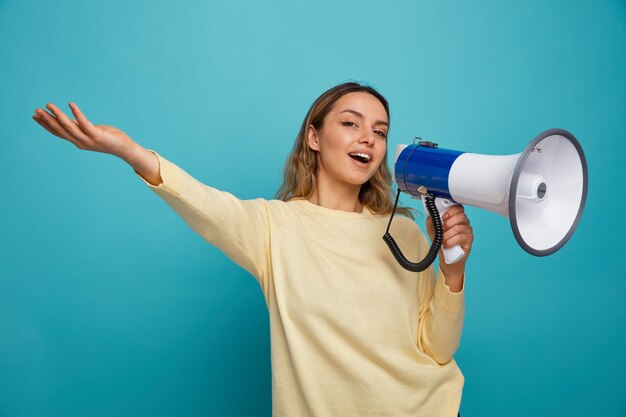 Excited young girl talking by speaker stretching out hand 