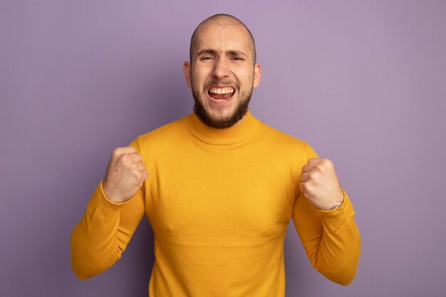 Excited  young handsome guy showing yes gesture isolated on purple wall