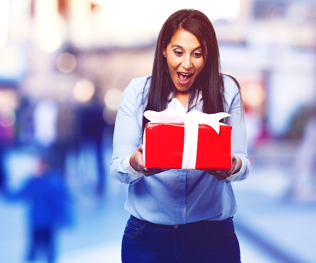 Excited young lady with a gift in her hands