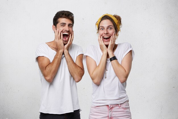 excited young male and female feeling amazed