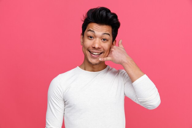 Excited young man doing call gesture 