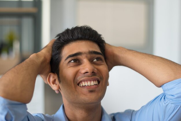 Excited young man holding head in hands