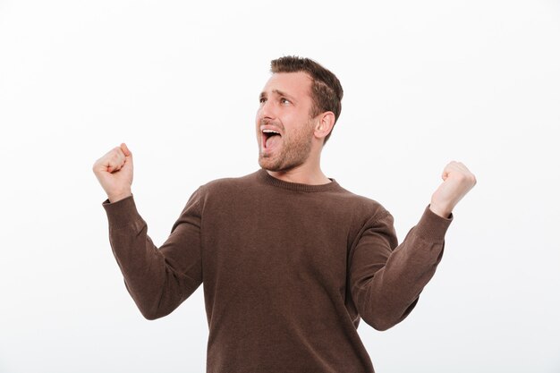 Excited young man make winner gesture.