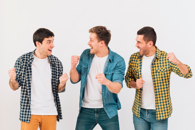 Excited young men cheering and making fun against white backdrop