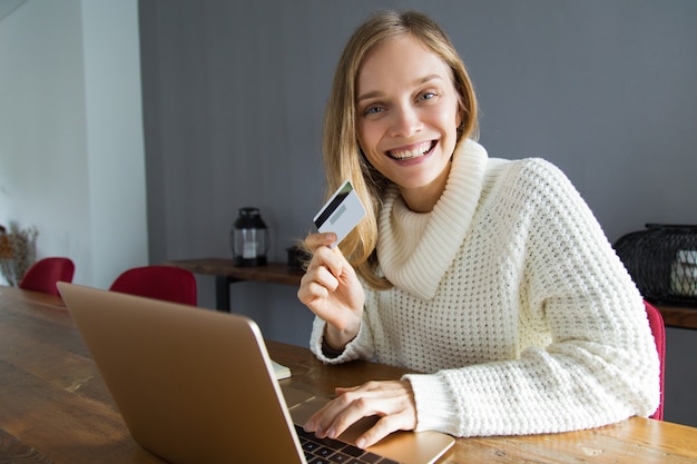 Excited young woman doing online shopping at home
