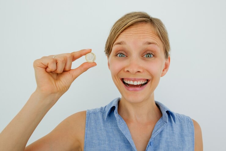Free Photo excited young woman holding one euro coin