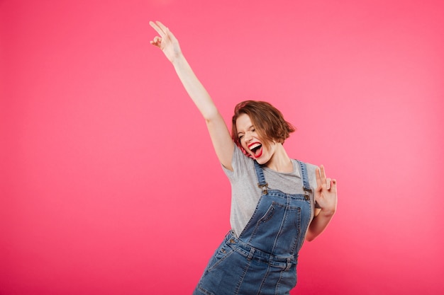 Excited young woman isolated over pink