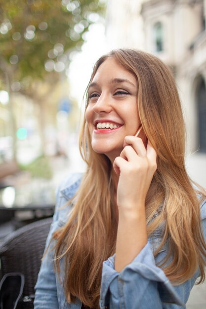 屋外で話している間に笑っている興奮した若い女性