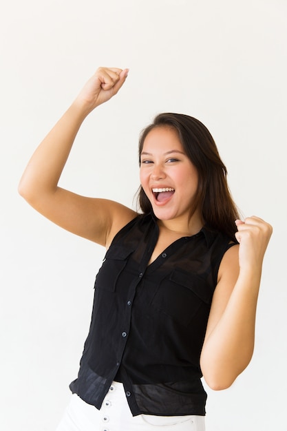 Excited young woman raising fists