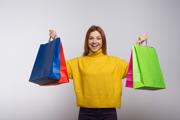 Excited young woman with colorful shopping bags