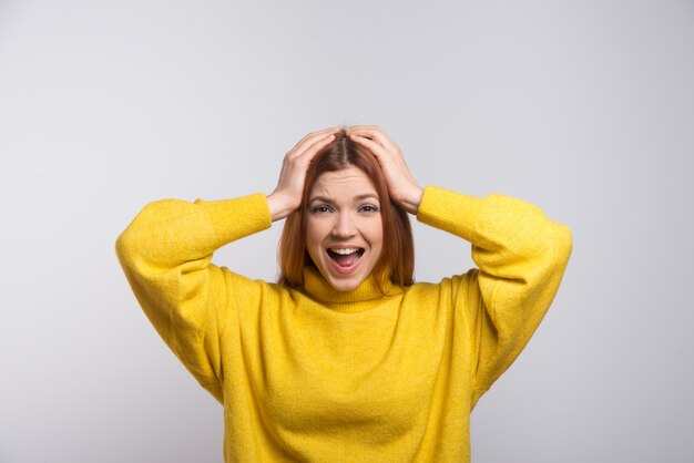 Excited young woman with hand on head