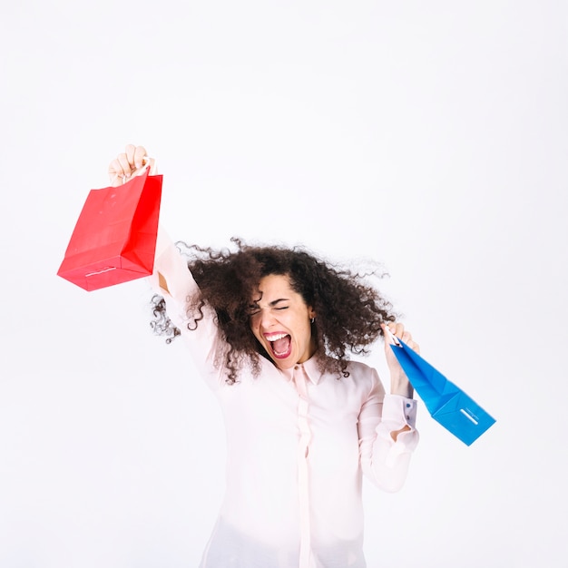 Free photo excited young woman with paper bags