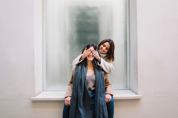 Excited young women posing in love outside