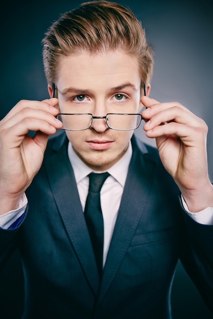 Free photo executive putting on his glasses