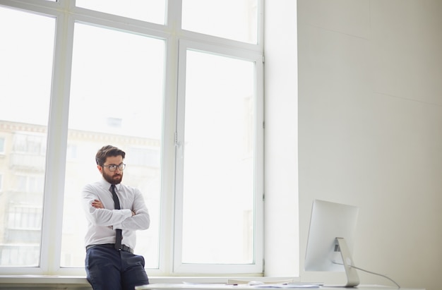 Executive with crossed arms looking at the computer