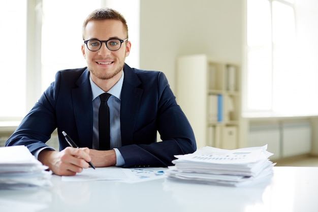 Foto gratuita esecutivo con gli occhiali che lavorano in ufficio