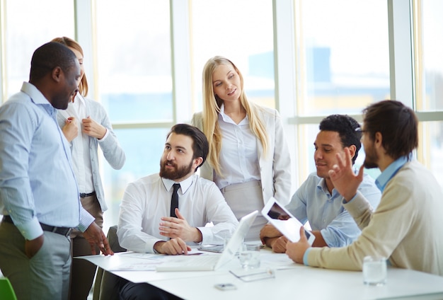 Executives with digital tablet having meeting in office