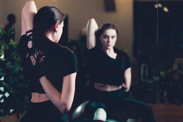 Foto gratuita esercitazione della donna che riflette sullo specchio in palestra