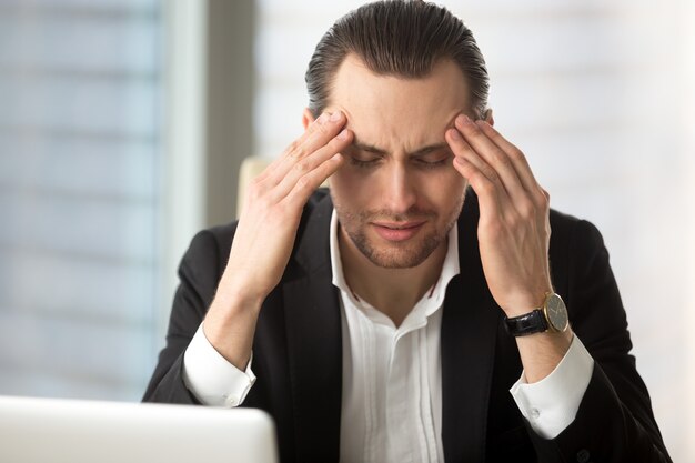 Exhausted businessman having a headache 