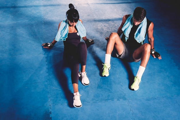 Exhausted couple on floor in gym