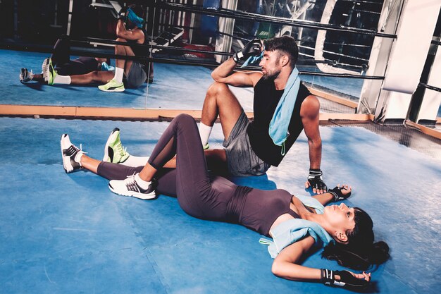 Exhausted couple on floor in gym