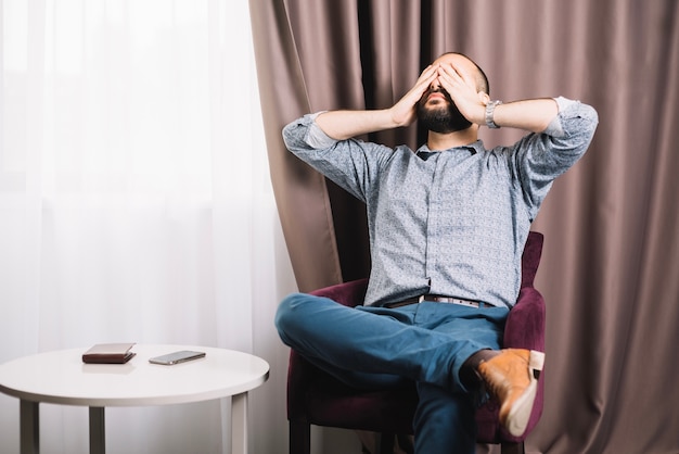 Exhausted man sitting in armchair