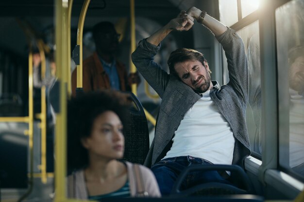 버스로 여행하는 동안 스트레칭 지친 남자