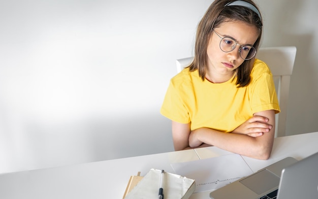 Free photo exhausted schooler girl suffering from doing homework tired from studying