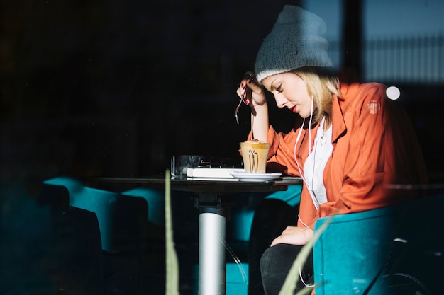 Foto gratuita esausta donna seduta nel caffè