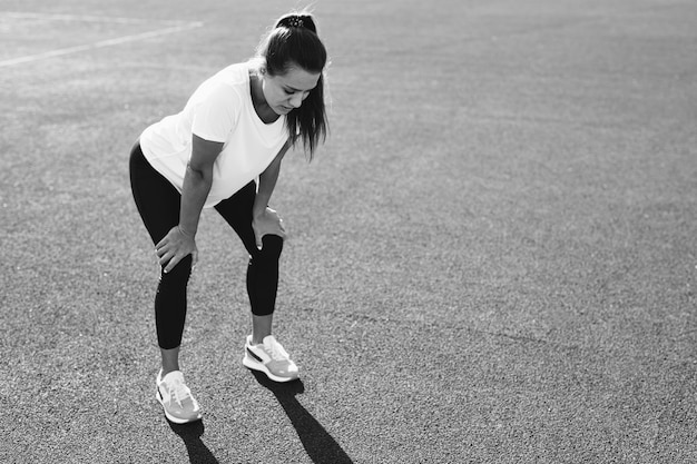 Exhausted woman in sportswear relaxing after morning run