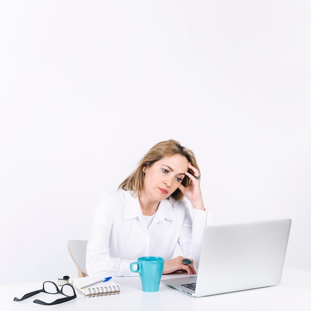 Free photo exhausted woman working on laptop