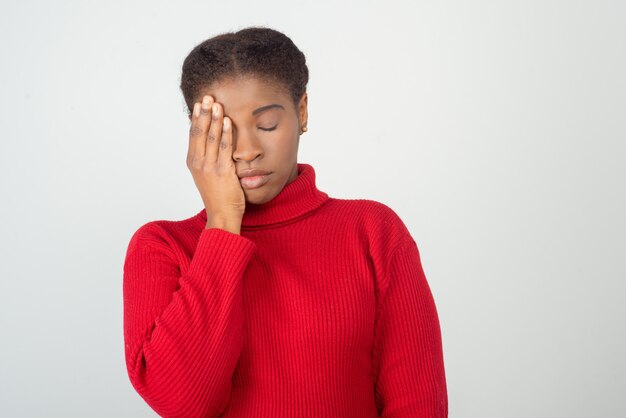 Exhausted young woman holding hand on head