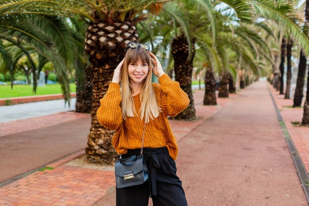 Donna bionda uscita in occhiali da sole alla moda che posano sopra il lungomare a barcellona