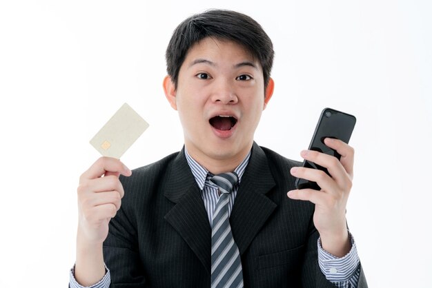 Вышедший бизнес-азиатский мужчина держит кредитную карту в руке, готовую к покупкам концепции бизнес-идей