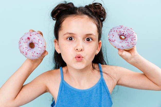 Exited girl holding two doughnuts