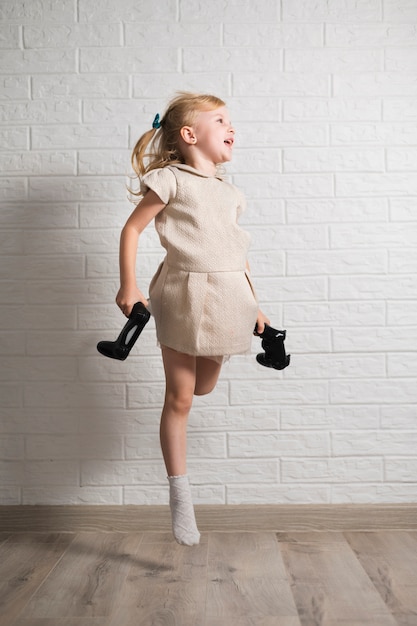 Exited girl with joysticks in hands jumping