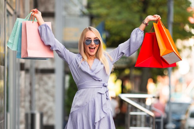 Exited young woman with shopping bags